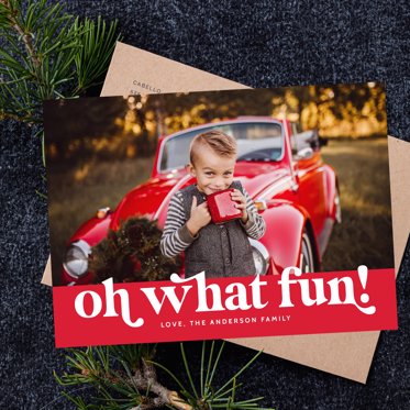 Christmas Photo Card from Mpix with "oh what fun" written in white on a red background and room for a photo of your choice sitting on a kraft envelope