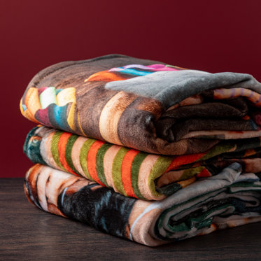 A stack of personalized blankets from Mpix laying on a table.