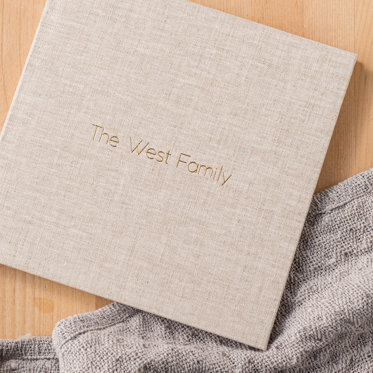 A lightly colored linen cover with 'The West Family' in gold debossing.