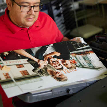 A worker in our lab inspects a large giclee print for quality.