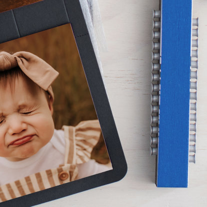 A pack of 12 push-pins sitting next to a picture of a toddler. 