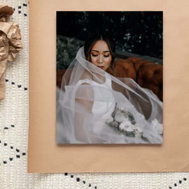 Giclee Photo Print pinned to a sheet of kraft paper featuring a bridge with a flowing veil holding flowers on her wedding day. 