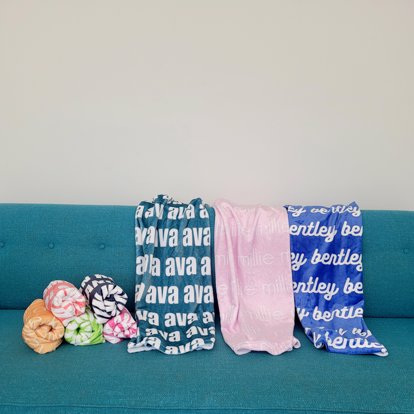 Three name blankets on a couch.