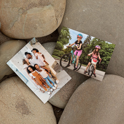 Photo prints set on top of rocks in the sand featuring summer family photos.