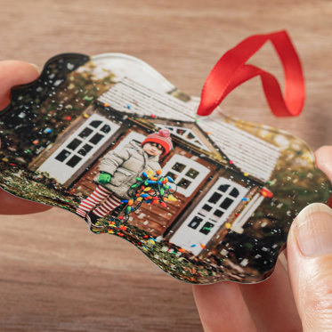 Ornate shaped ornament with a red ribbon for hanging featuring a photo of a brother and sister smiling.