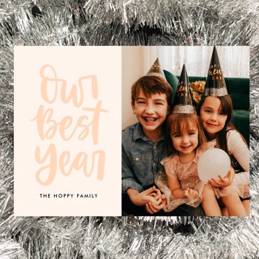 A Card Celebrating the New Year with "Out Best Year" written in bubble script on a pale background and room for a personalized photo. 