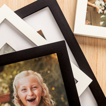 A stack of tabletop frames showcasing our black and white frames with or without window mat.